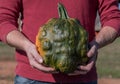 Man Holds Bumpy Green Pumpkin