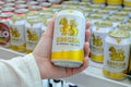 Man holds a can of popular Thai beer Singha in his hand