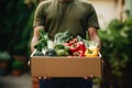 a man holds a cardboard box with groceries in his hands. Food service and delivery concept. Copy space mockup Royalty Free Stock Photo