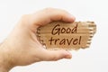 A man holds a cardboard in his hand on which it is written - Good travel