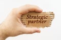A man holds a cardboard in his hand on which it is written - Strategic partner