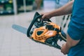 A man holds a chain saw in his hand. A buyer in a hardware store selects a product