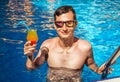 Man holds a cocktail in the swimming pool Royalty Free Stock Photo