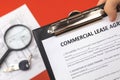 Man holds commercial lease agreement in hand. Clipboard with official document. Background with real property papers and Royalty Free Stock Photo