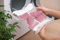 A man holds a dirty dryer filter. A man collects lint, hair, wool from the filter of drying machine. Red lint on the