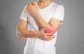 A man holds the elbow. The pain in my arm. A sore point in red. Royalty Free Stock Photo