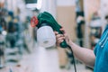 A man holds an electric spray gun in his hand. A buyer in a hardware store selects a product