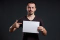 Man holds an empty poster paper sheet in his hands. Smile and joy, place for text, copy space Royalty Free Stock Photo