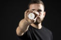 Man holds ethereum coin. Young bearded man holding virtual currency ethereum.