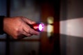 A man holds a flashlight in dark room. Penetration into someone else`s home_