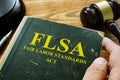 Man Holds FLSA Fair Labor Standards Act Book