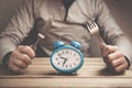 Man holds fork with knife. Time to eat.