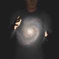 Man holds galaxy between hands