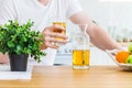 Man holds a glass of apple juice sitting at the kitchen table