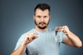 A man holds a glass of water and a pill, taking medication, treatment, gray background. Medical theme, vitamins, health care Royalty Free Stock Photo