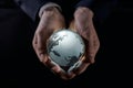 A man holds a glowing globe in his hands. close-up on a black background Royalty Free Stock Photo