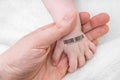Man holds hand of a baby with bar code on it. Genetic cloning concept Royalty Free Stock Photo