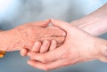 Man holds hands of eldery woman. Senior help and assistance concept