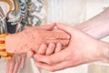 Man holds hands of eldery woman. Senior help concept