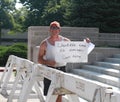 Man holds handwritten sign at Rally to Secure Our Borders