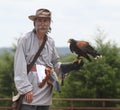 Man holds a hawk during a falconry demonstration