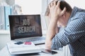 Man holds head with hands on table with laptop. Unemployment,crisis,stress,job loss.Looking for remote work at home.Mobile phone, Royalty Free Stock Photo