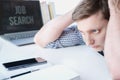 Man holds head with hands on table with laptop. Unemployment,crisis,stress,job loss.Looking for remote work at home.Mobile phone, Royalty Free Stock Photo