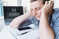 Man holds head with hands on table with laptop. Unemployment,crisis,stress,job loss.Looking for remote work at home.Mobile phone, Royalty Free Stock Photo