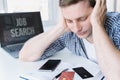 Man holds head with hands on table with laptop. Unemployment,crisis,stress,job loss.Looking for remote work at home.Mobile phone, Royalty Free Stock Photo