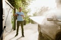 Man holds high pressure water gun, car wash Royalty Free Stock Photo