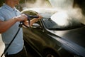 Man holds high pressure water gun, hand car wash Royalty Free Stock Photo
