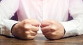 A man holds his closed fists on the table. An attack of anger, stress. A decisive, emotional gesture. Impulsive men. To suffer Royalty Free Stock Photo