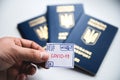 A man holds in his hand a drawn stamp with the inscription `coronavirus` on the background of foreign passports