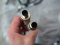 A man holds in his hand a round eight-pin metal cable connector Royalty Free Stock Photo