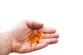 A man holds in his hand several fish oil capsules. Omega 3 and vitamin D pills.