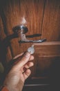 A man holds in his hand a small light broken key against the background of a door lock Royalty Free Stock Photo