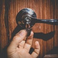 A man holds in his hand a small light broken key against the background of a door lock Royalty Free Stock Photo