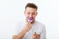 A man holds in his hand an ultraviolet lamp for home teeth whitening. A snow-white smile after bleaching.