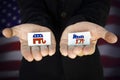 man holds in his hands Elephant symbol of the Republican Party and Donkey symbol of the Democratic Party, with the