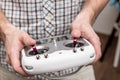 Man holds in his hands remote control for multicopter, indoors.