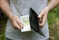 A man holds in his hands and shows an empty purse and a five euro banknote. The concept of economic and financial crisis, poverty Royalty Free Stock Photo