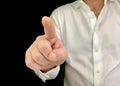 A man holds his index finger in front of him. A man in a white shirt shows a finger forward, on a black background. Concept: click Royalty Free Stock Photo