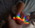 A man holds his newborn son by the leg. Beam of light through a prism. Royalty Free Stock Photo