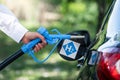 Man holds a hydrogen fueling nozzle. Refueling car with hydrogen fuel. Concept.