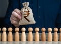 A man holds a indian rupee money bag above the crowd.Salaries.