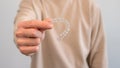 Man holds invisalign transparent braces for dental correction. Dentist office