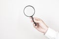Man holds magnifying glass on wall background. Concept of search, recruitment and job search