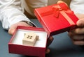 Man holds a miniature house in a gift box. Housing as a gift. Win an apartment in the lottery. To inherit property. Holiday