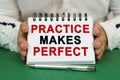 A man holds a notepad in his hands with the inscription - Practice Makes Perfect Royalty Free Stock Photo