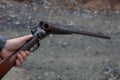 A man holds an old, antique, double-barrel break action shotgun out, ready to load two rounds into the bore. Royalty Free Stock Photo